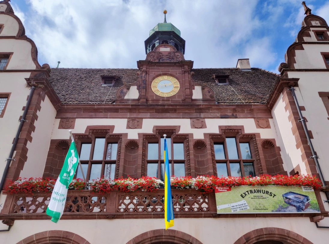 fachada del ayuntamiento nuevo con reloj central ornamentado y balcón principal de arquitectura gótica
