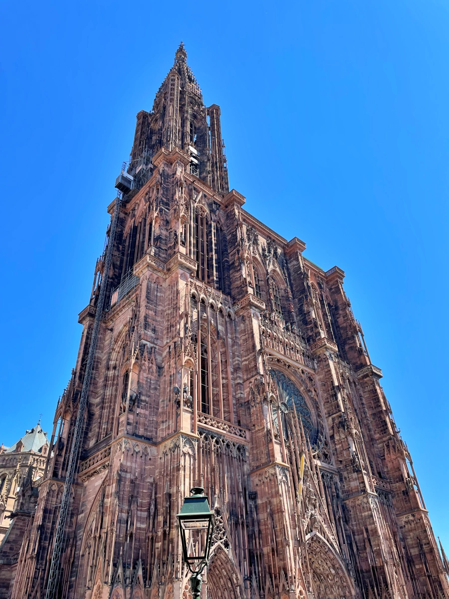 Fachada principal y torre de la Catedral de Estrasburgo en piedra rosa bajo cielo azul