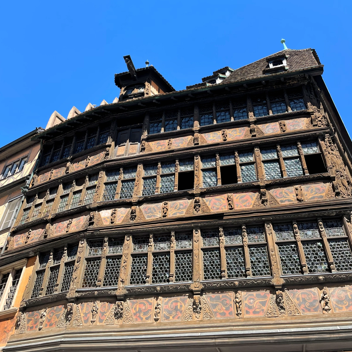 Detalle lateral de la Casa Kammerzell en Estrasburgo mostrando ventanas decoradas, entramado de madera y relieves renacentistas