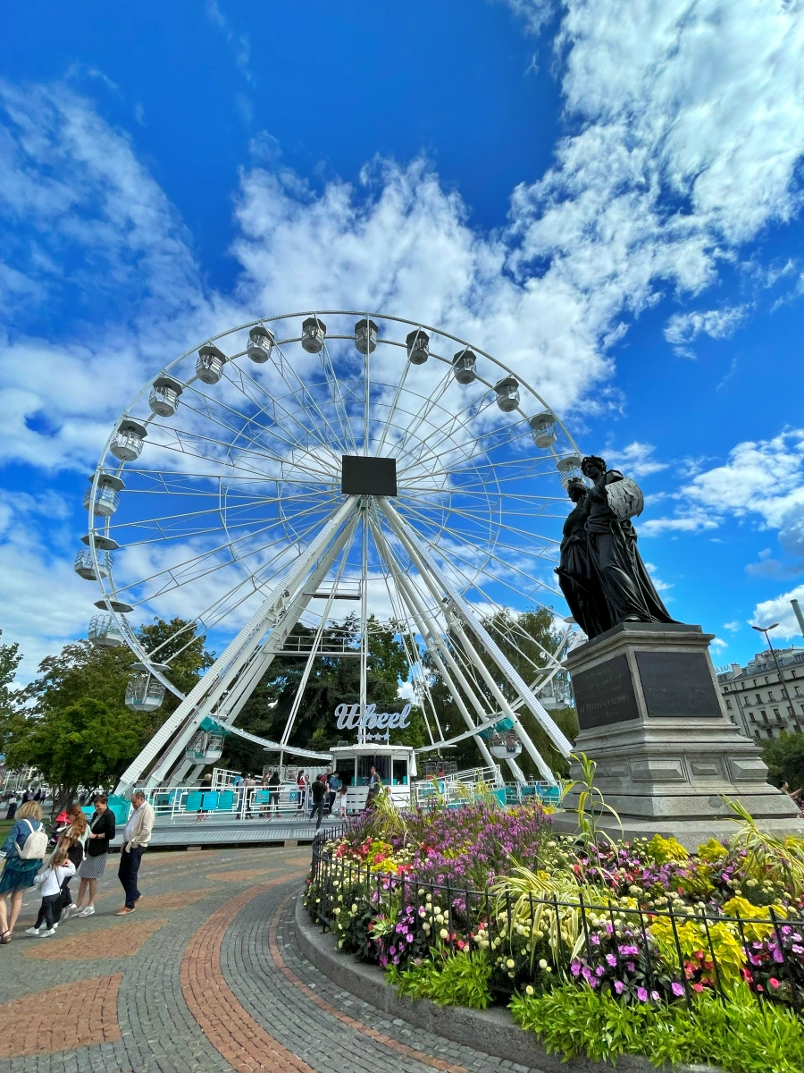 Monumento Nacional de Ginebra con esculturas de bronce y la noria panorámica al fondo en el Jardín Inglés, junto al lago Lemán