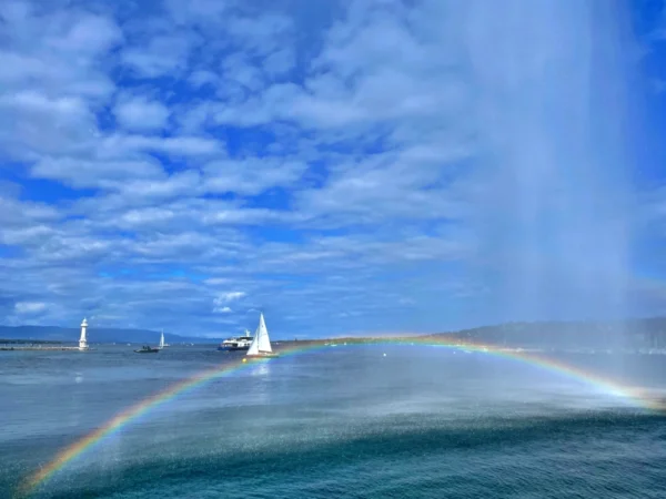 Detalle del agua cayendo del Jet d’Eau de Ginebra formando un arcoíris sobre el lago Lemán en un día soleado