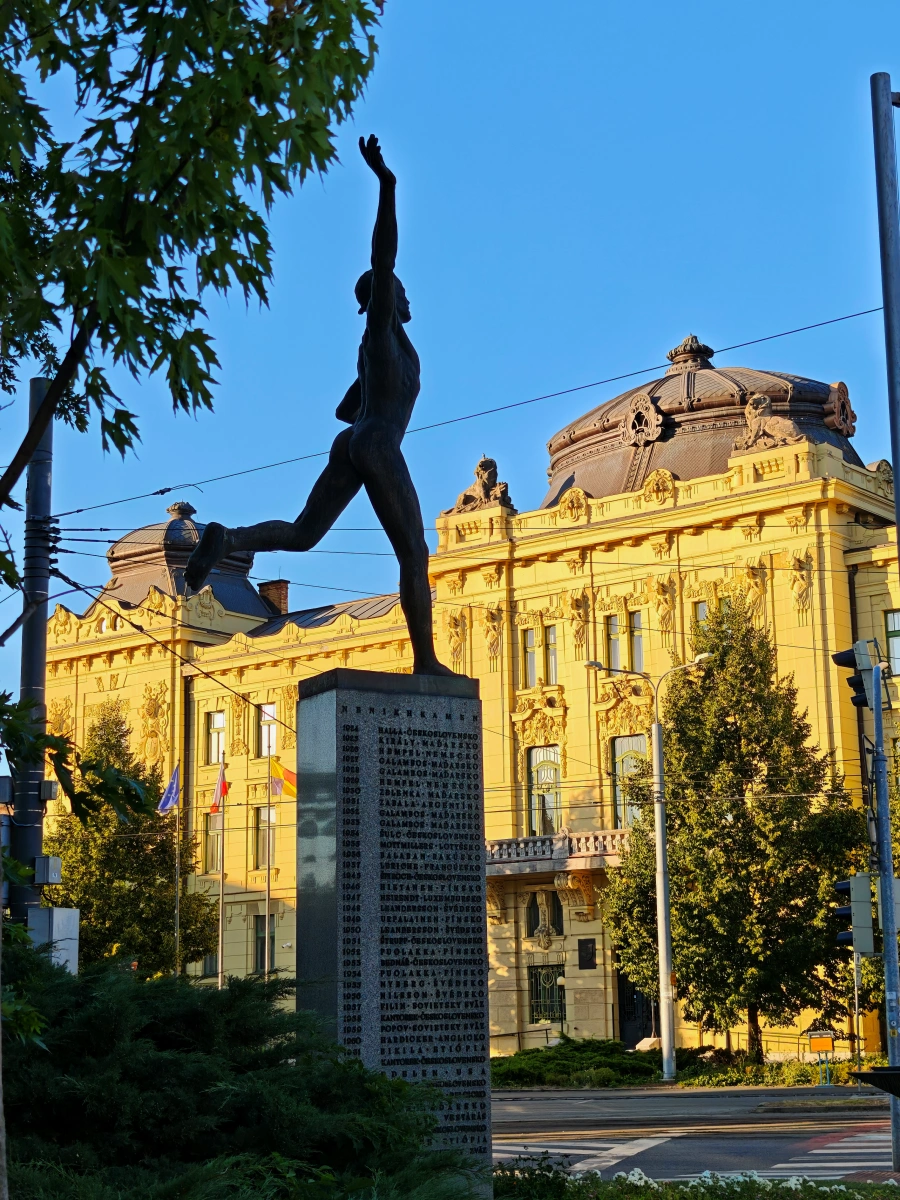 Estatua de bronce del maratoniano conocido como "Heraldo de la Victoria" en la Plaza del Maratón de la Paz en Košice, Eslovaquia, obra del escultor Arpád Račko de 1959, con pedestal donde figuran los nombres de ganadores históricos del maratón.