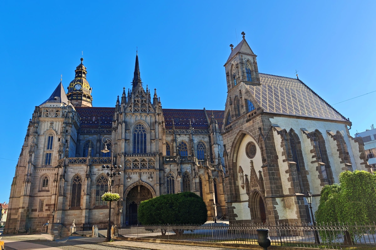 Vista panorámica de la Catedral de Santa Isabel y la Capilla de San Miguel en Košice, Eslovaquia, con detalles góticos y cielo azul claro, monumentos históricos en el centro de la ciudad.