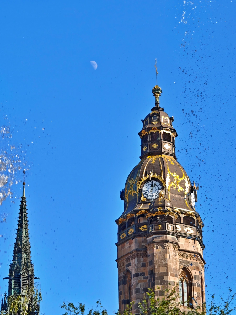Detalle arquitectónico de las dos torres de la Catedral de Santa Isabel en Košice, Eslovaquia, con reloj y detalles dorados bajo un cielo azul, ideal para turismo cultural en Košice.