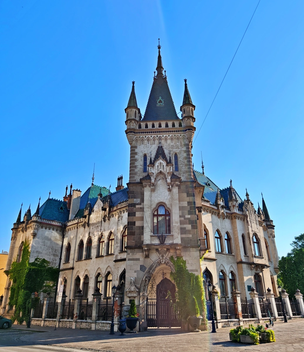 Vista frontal del Palacio Jakab en Košice, Eslovaquia, con su torre central y detalles neogóticos bajo un cielo despejado.