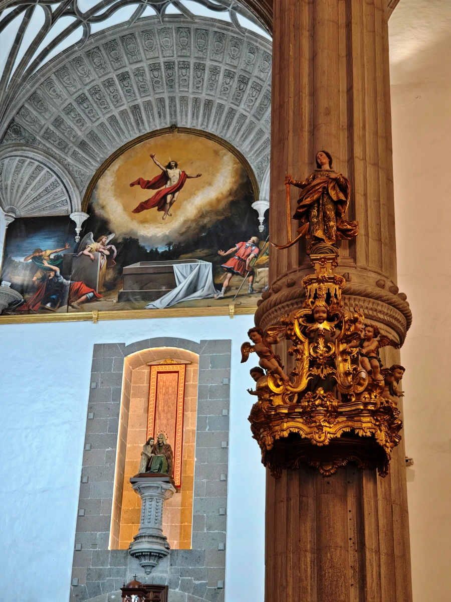 Interior de la Catedral de Santa Ana con columnas ornamentadas, esculturas religiosas y frescos artísticos en Las Palmas de Gran Canaria.
