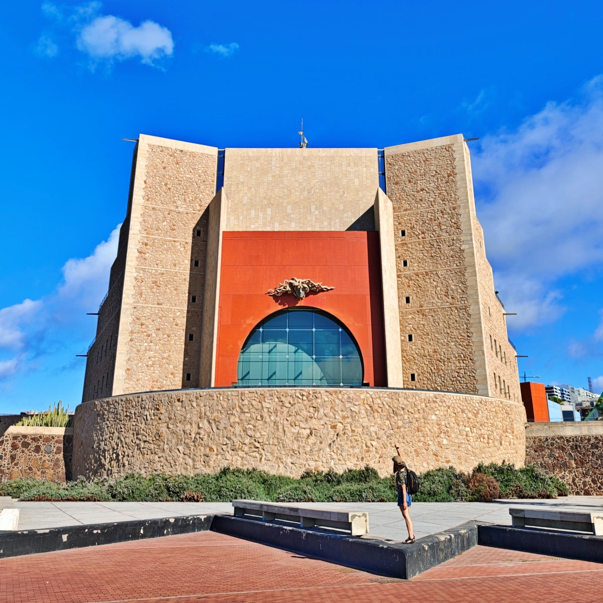 Imagen trasera del Auditorio Alfredo Kraus de Las Palmas con su enorme ventana panorámica abierta directamente al océano Atlántico bajo el cielo azul.