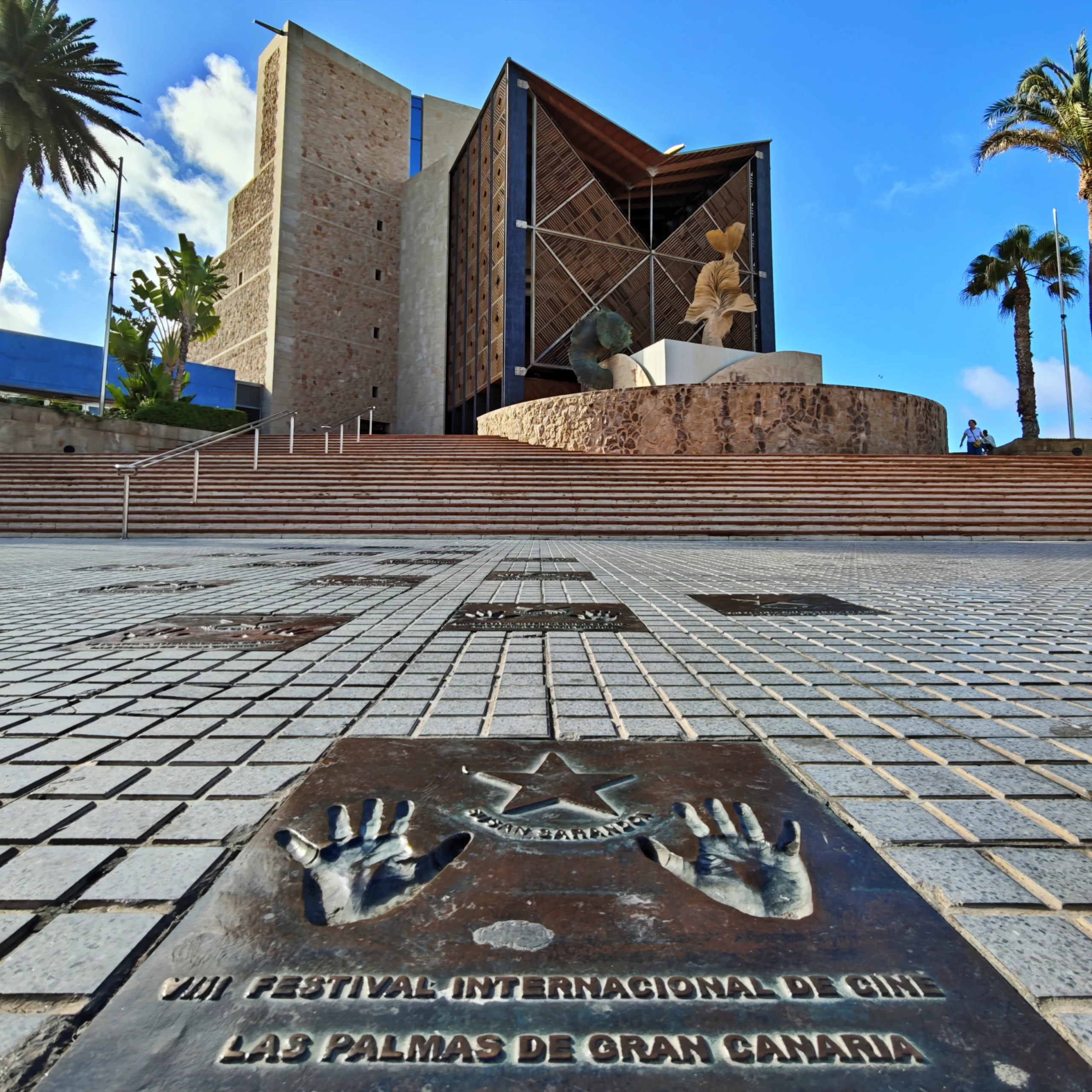 Vista frontal del Auditorio Alfredo Kraus en Las Palmas con la placa de huellas de Susan Sarandon del Festival Internacional de Cine en primer plano.