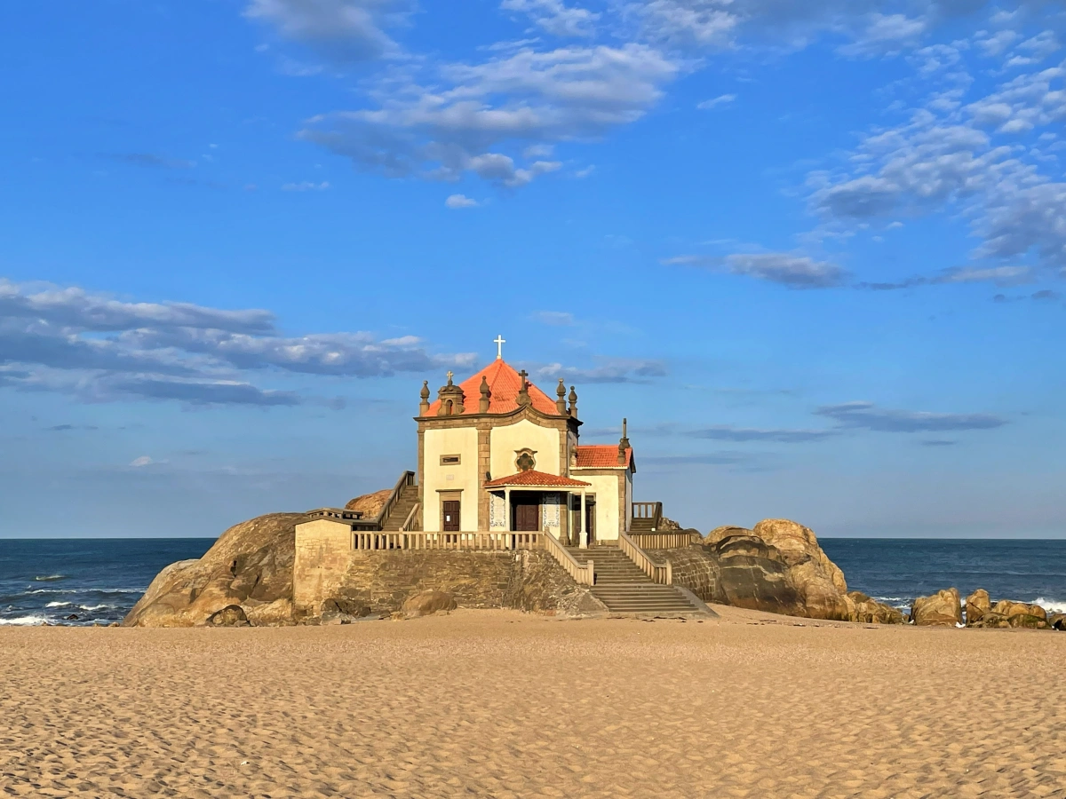 Pequeña capilla blanca sobre rocas en la Playa de Miramar, Oporto