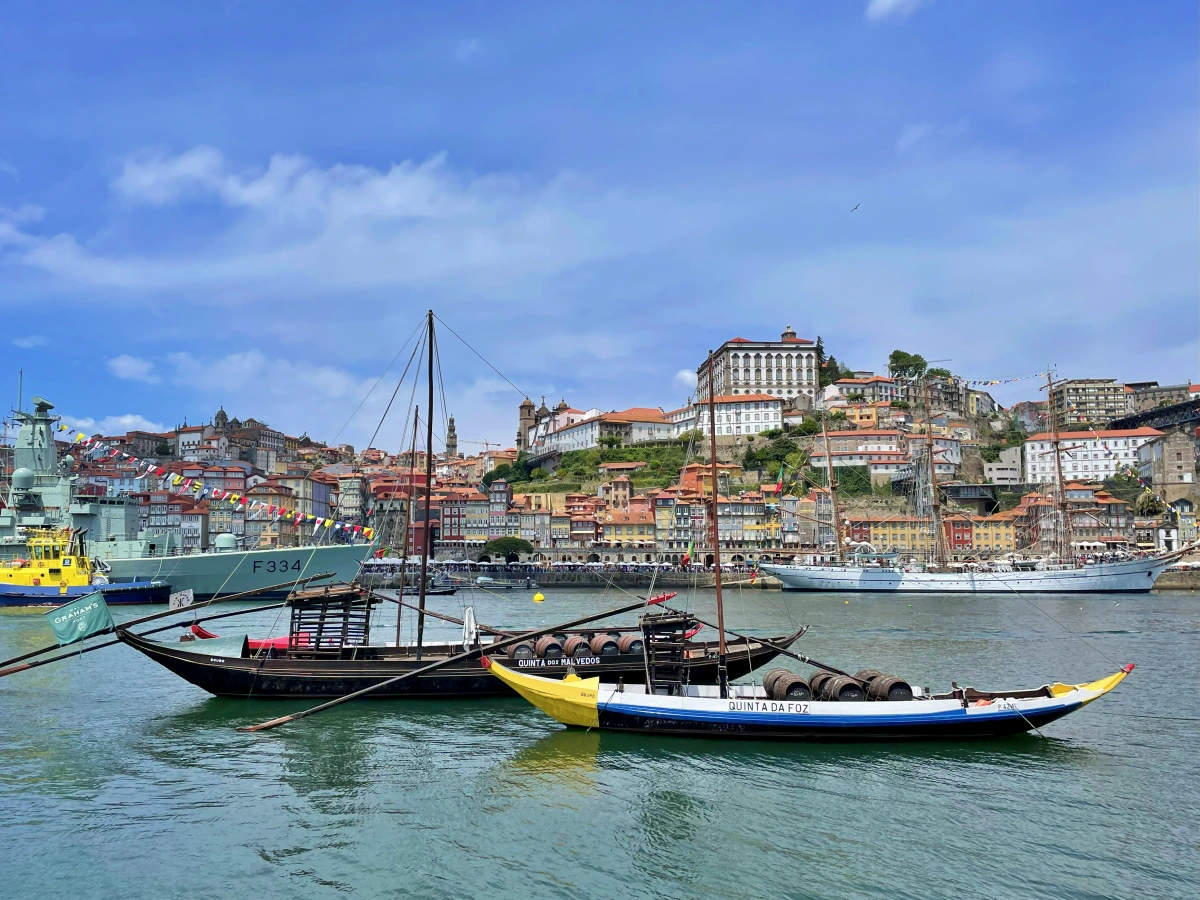 Varios rabelos coloridos atracados en el río Duero con la ciudad de Oporto al fondo