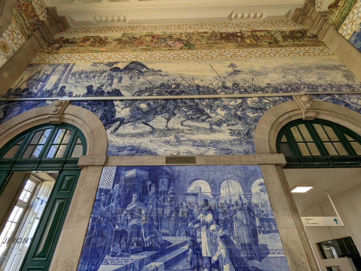 Mural de azulejos azul y blanco que representa escenas históricas en la estación de São Bento