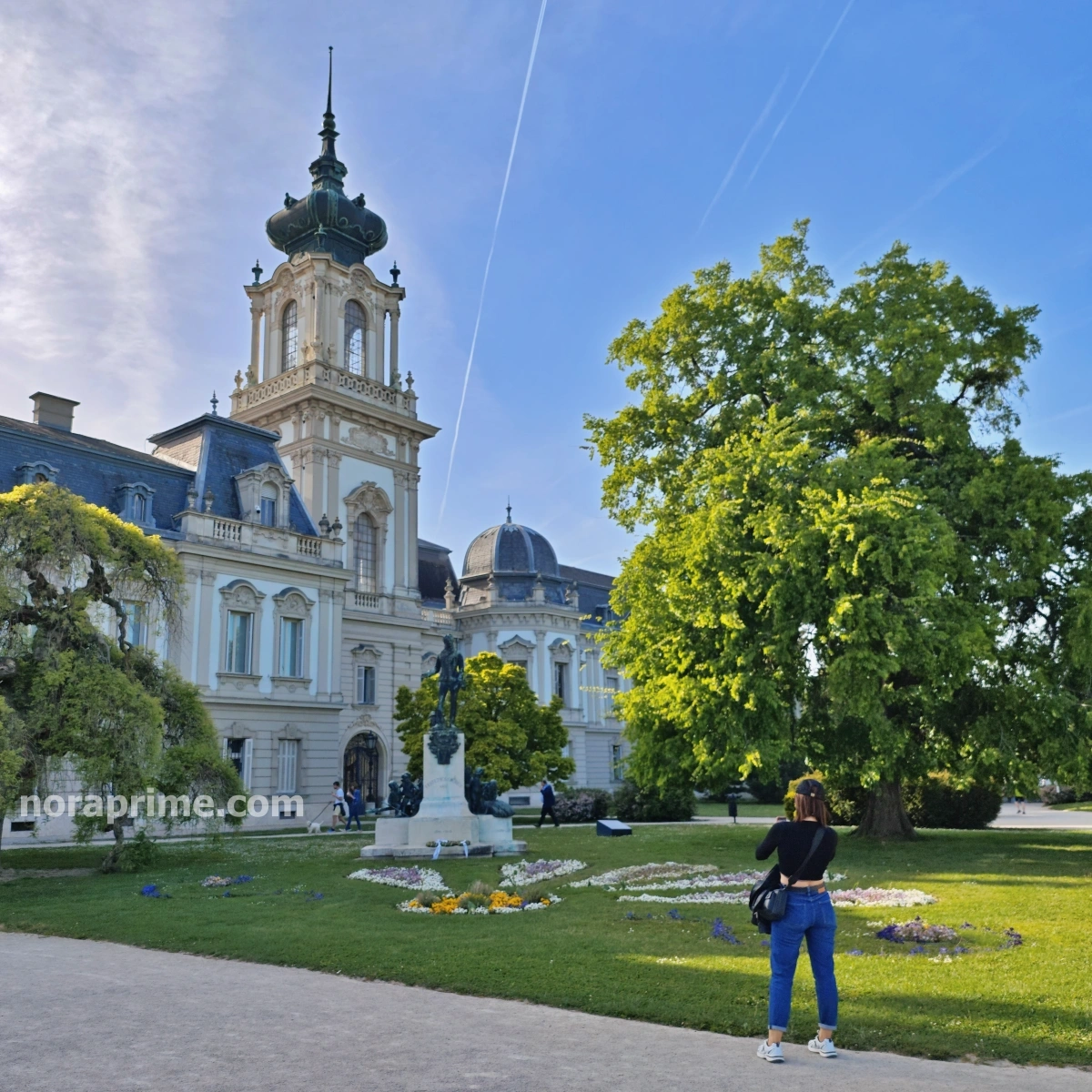 Vista del Palacio Festetics con su torre ornamentada, estatua y jardines floridos en Keszthely, Hungría