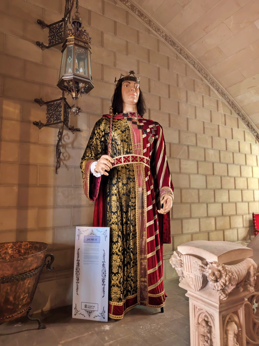 Figura del gegant Jaume II, ataviado con vestimenta medieval y corona, en exposición cultural de Palma de Mallorca