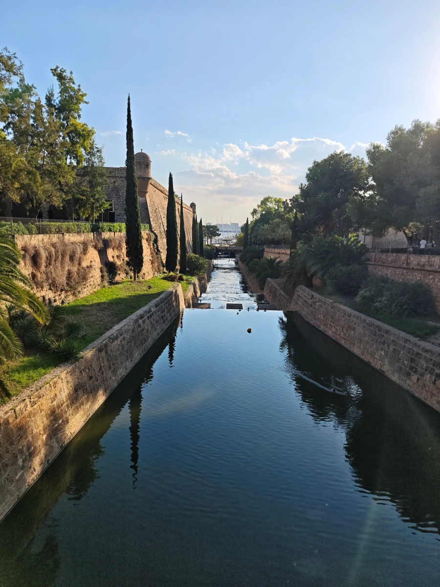 Cauce canalizado del torrente de Sa Riera en Palma, flanqueado por murallas y jardines urbanos