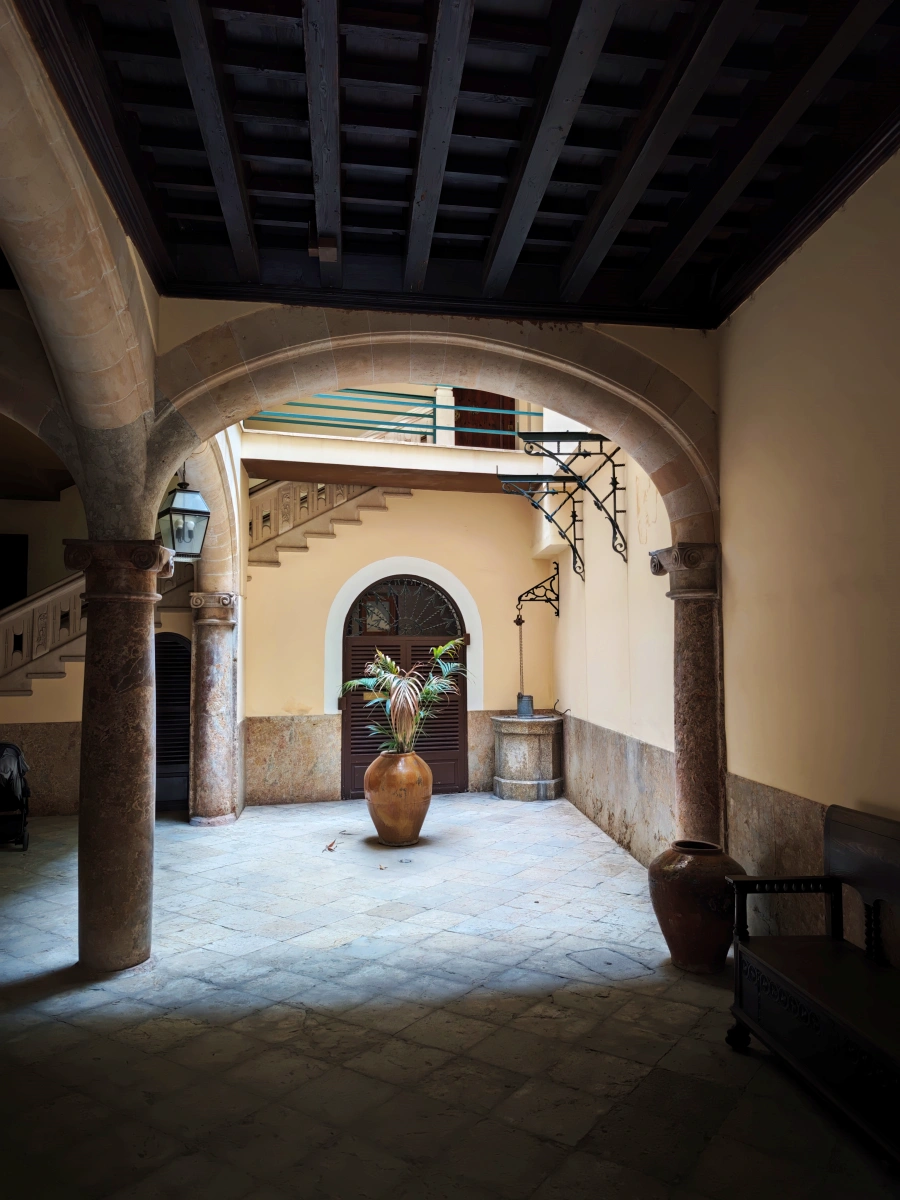 Patio tradicional de casa señorial en Palma con columnas, arcada y escalera noble