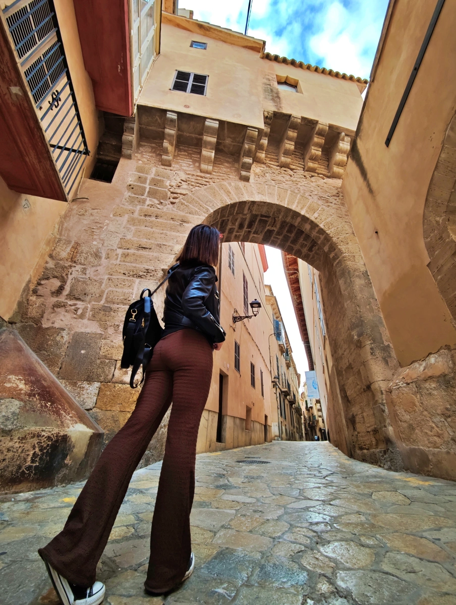 Persona junto a la puerta de la muralla romana en el barrio de la Almudaina, Palma de Mallorca