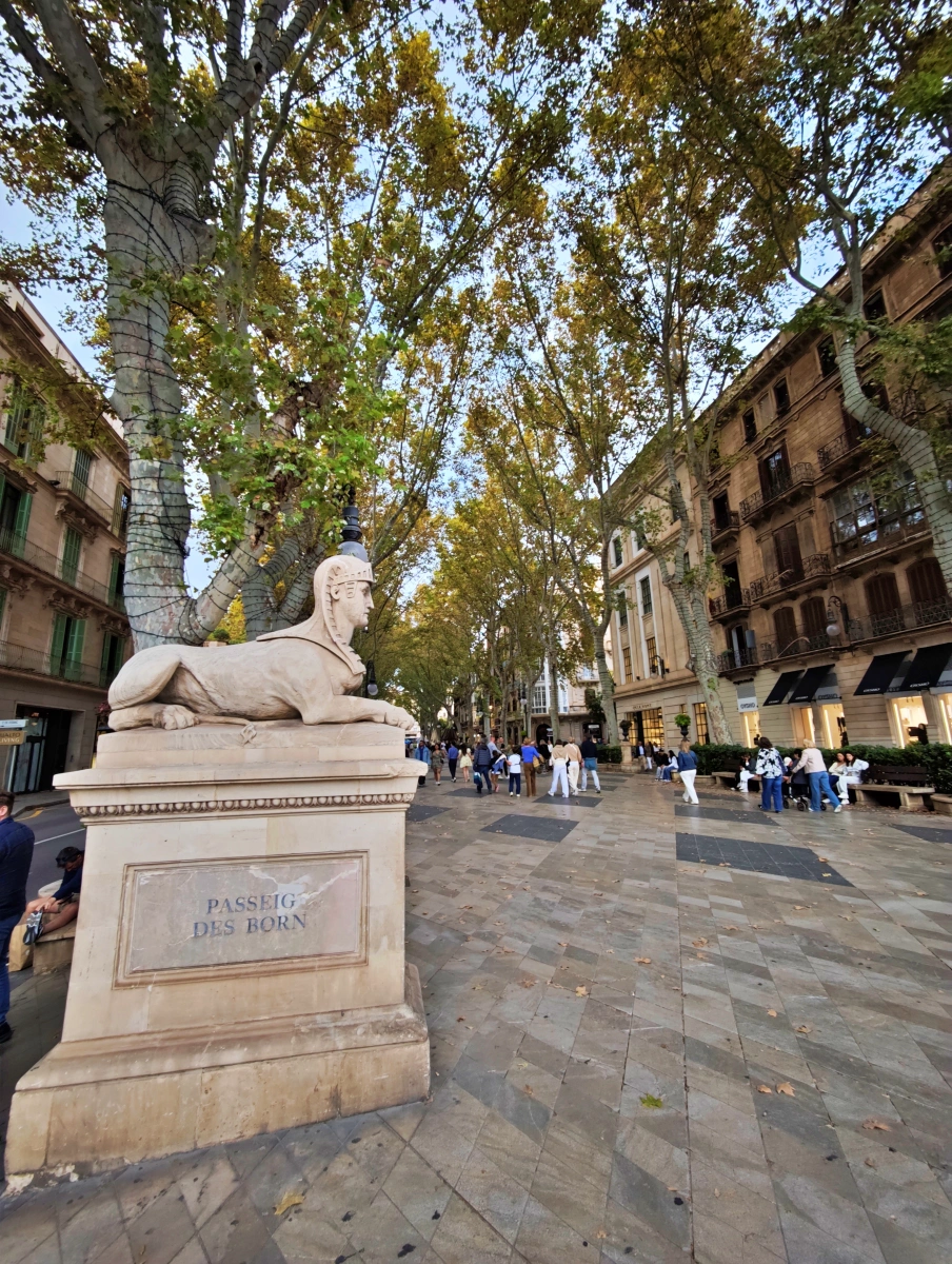 Escultura de esfinge y ambiente animado en el Passeig des Born de Palma de Mallorca