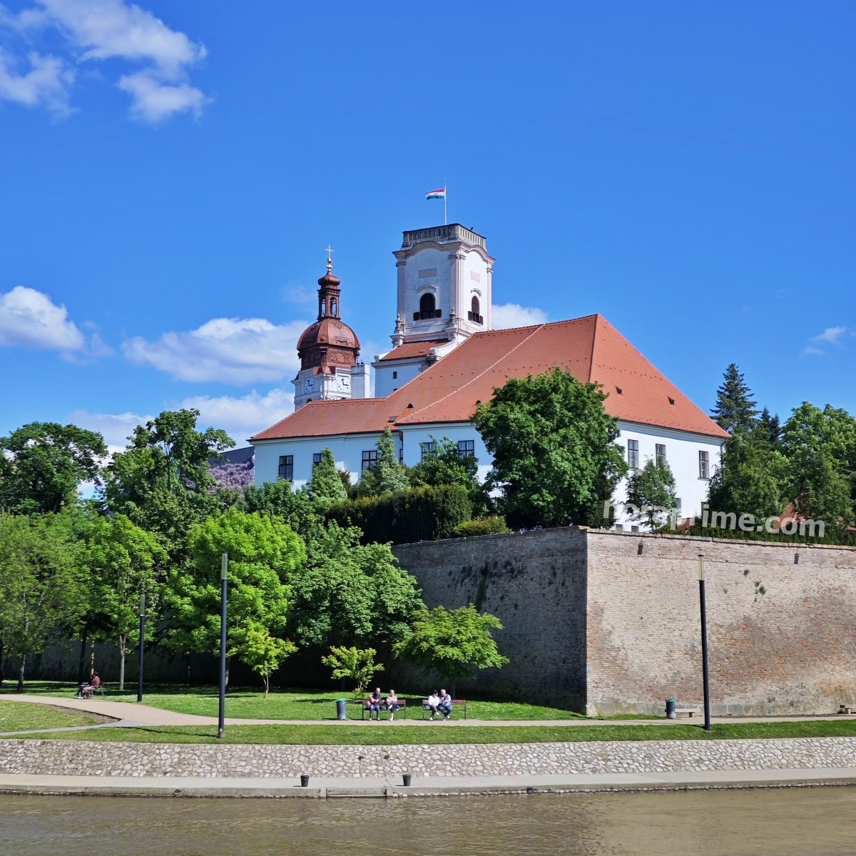 Murallas históricas y torre del castillo episcopal de Györ vistas desde el parque ribereño del río Rába