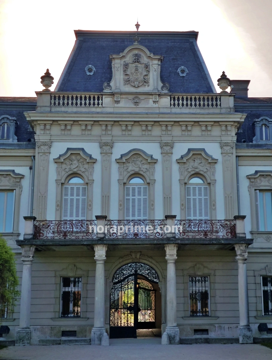 Detalle central de la fachada neobarroca del Palacio Festetics, con columnas, balcón y escudo en Keszthely, Hungría