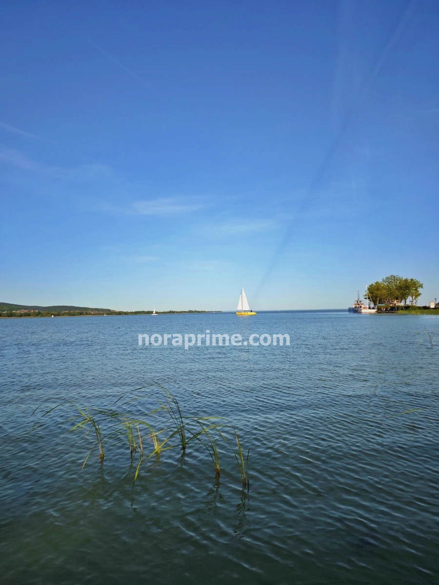 Panorámica del Lago Balaton con velero y vegetación desde la orilla de Keszthely, Hungría