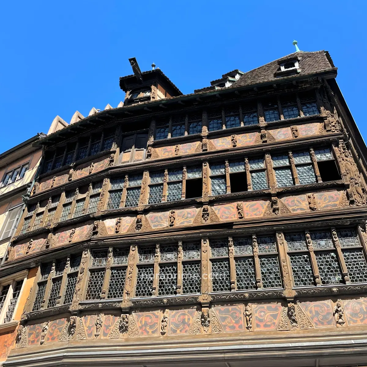 Detalle lateral de la Casa Kammerzell en Estrasburgo mostrando ventanas decoradas, entramado de madera y relieves renacentistas