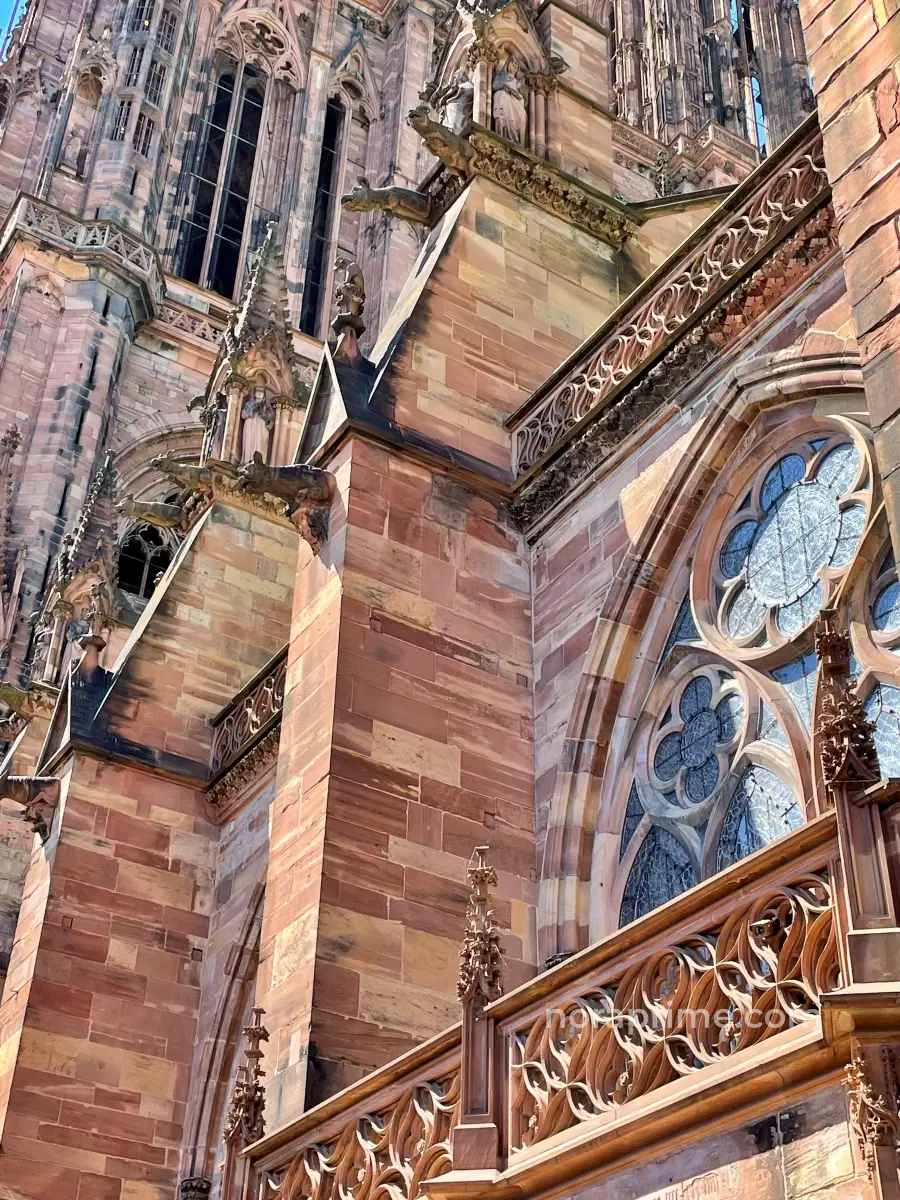 Detalle de la fachada gótica de la Catedral de Estrasburgo en piedra arenisca rosa con arbotantes y rosetón