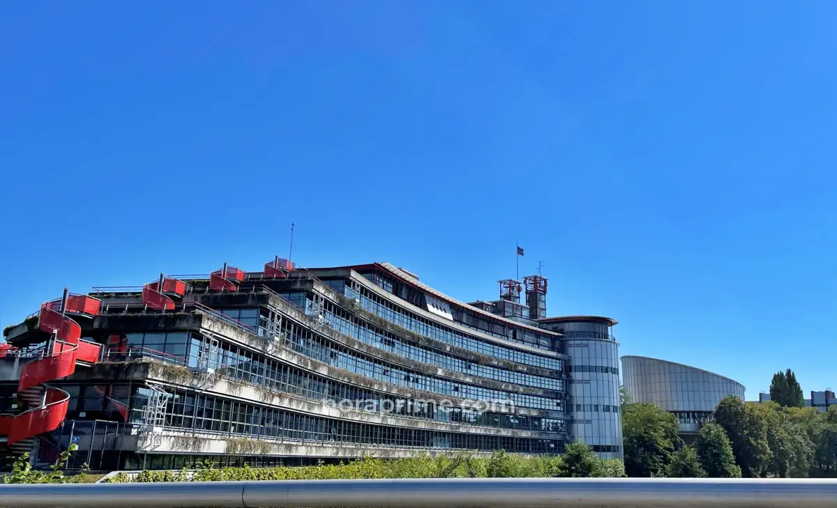 Fachada moderna de la Corte Europea de Derechos Humanos en Estrasburgo con estructura cilíndrica y detalles en rojo