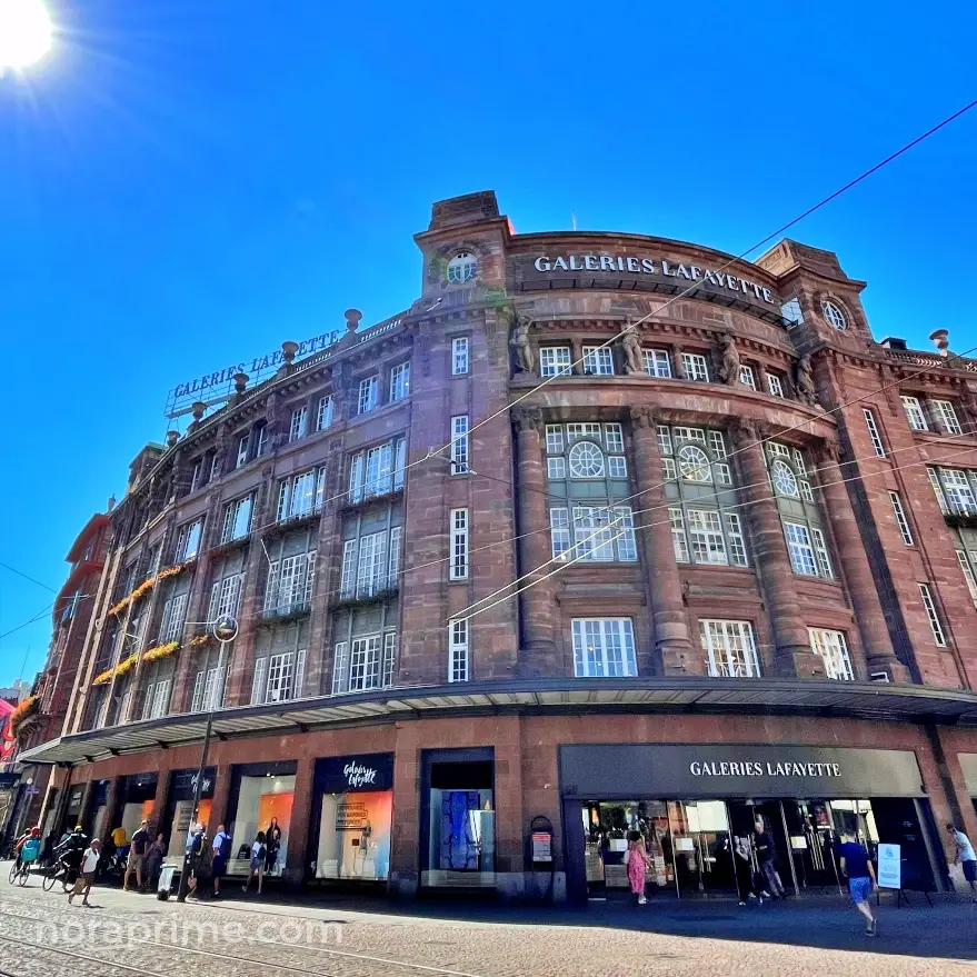 Fachada histórica de Galeries Lafayette en Estrasburgo con piedra rosa y columnas monumentales en la Place Kléber