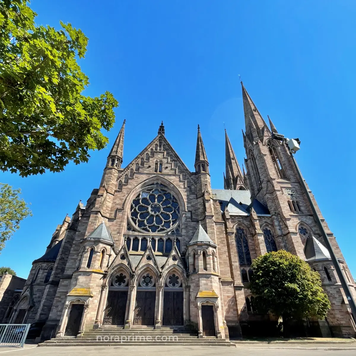 Vista lateral de la iglesia de San Pablo de Estrasburgo con fachada de piedra y pináculos góticos bajo cielo despejado