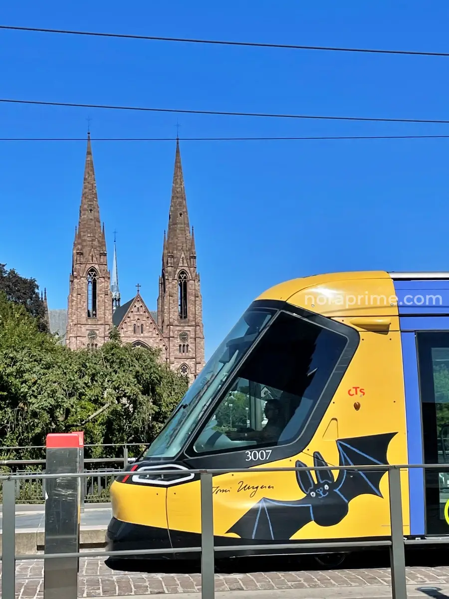 Iglesia de San Pablo de Estrasburgo vista desde el Pont Royal con tranvía CTS en primer plano y sus dos torres neogóticas al fondo