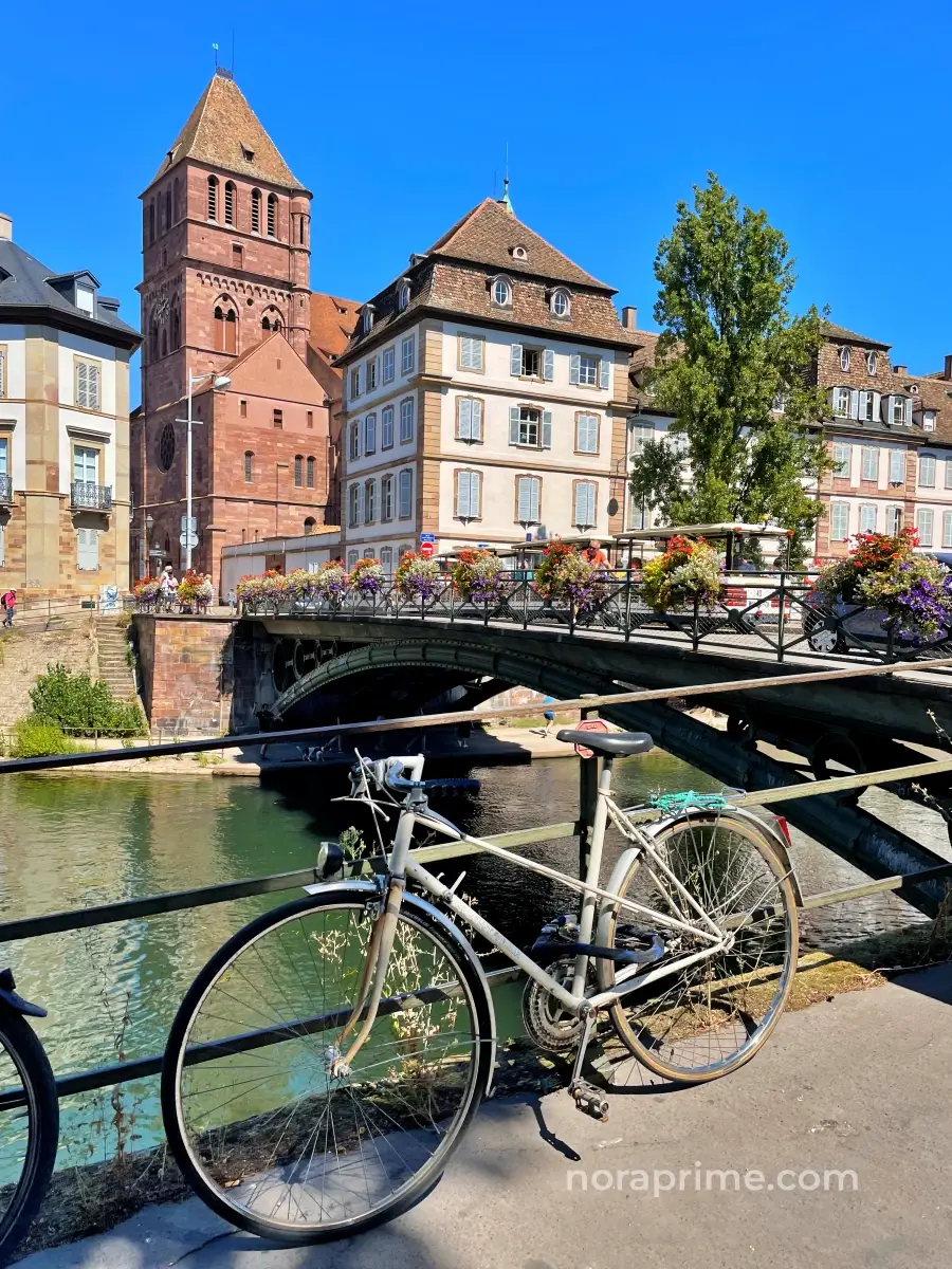Puente Saint-Thomas de Estrasburgo, puente de hierro fundido del siglo XIX sobre el río Ill con iglesia y edificios históricos al fondo